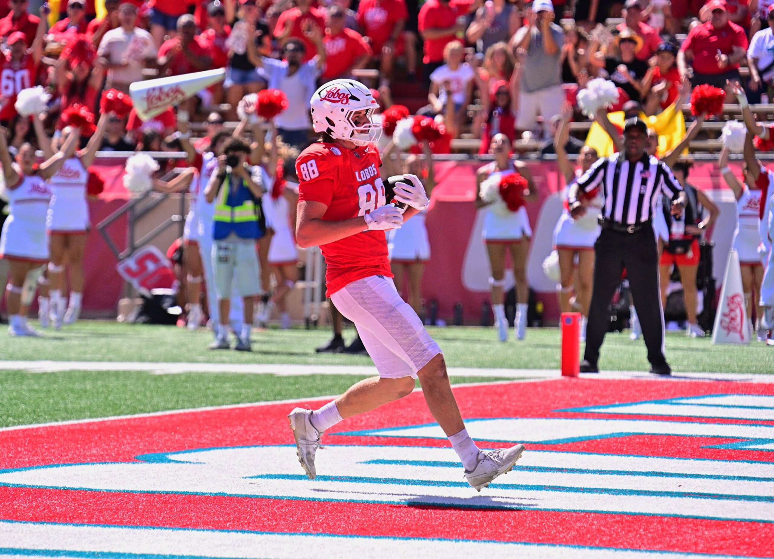 Breaking sports graphic showing a celebrating wolf mascot beside New Mexico’s 70-7 victory over Mercyhurst.